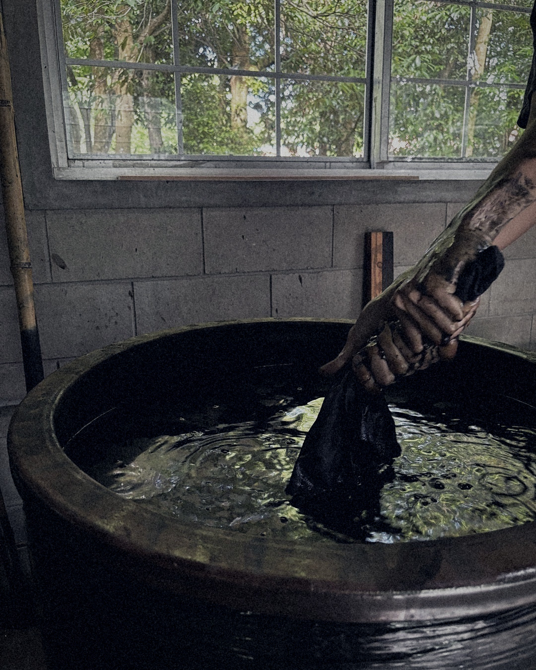 Artisan working cloth in the indigo vat